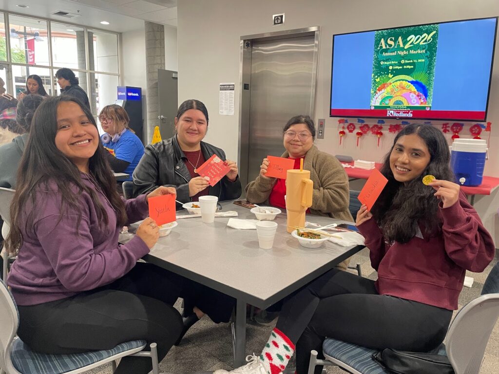 University of Redlands students hold red "Lucky Money" envelopes containing chocolate coins during a Lunar New Year celebration.
